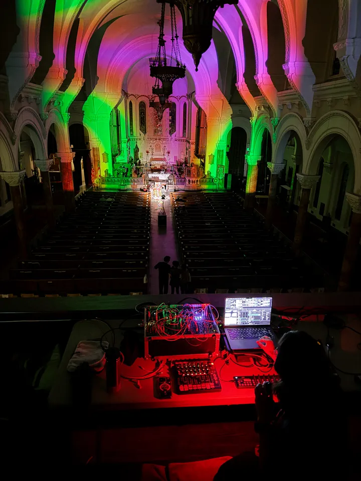 A dark church with colorful visuals by Paloma Kop projected onto the architecture