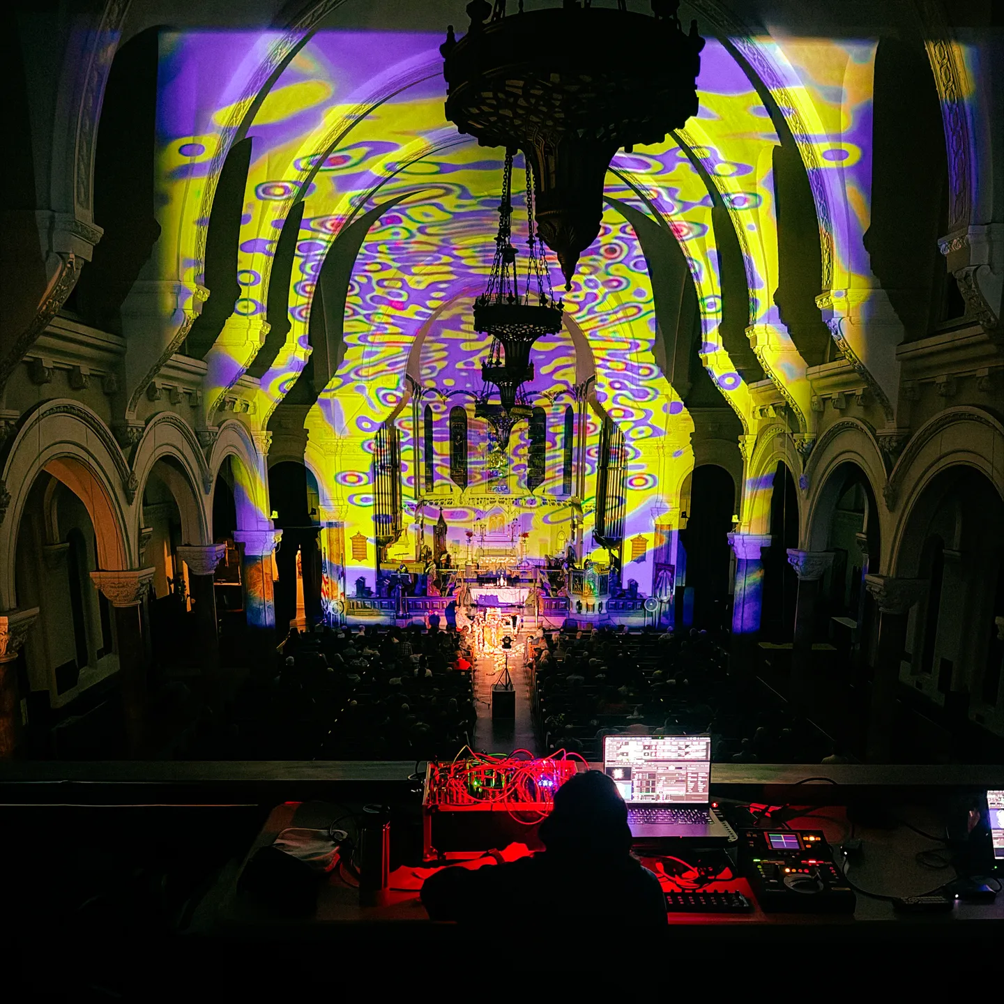 A dark church with colorful visuals by Paloma Kop projected onto the architecture
