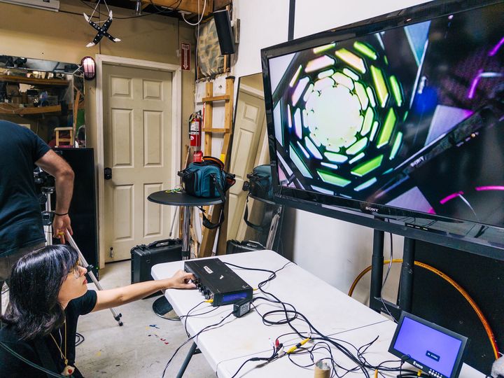 Person crouching and manipulating a large green spiral