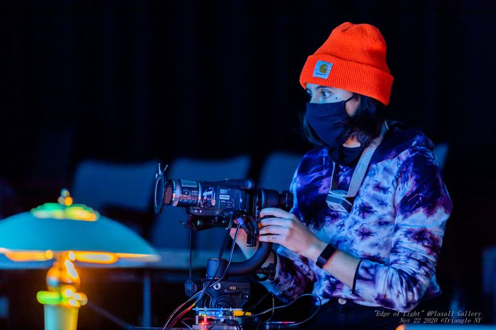 Closer view of the artist wearing a cloth mask and orange beanie