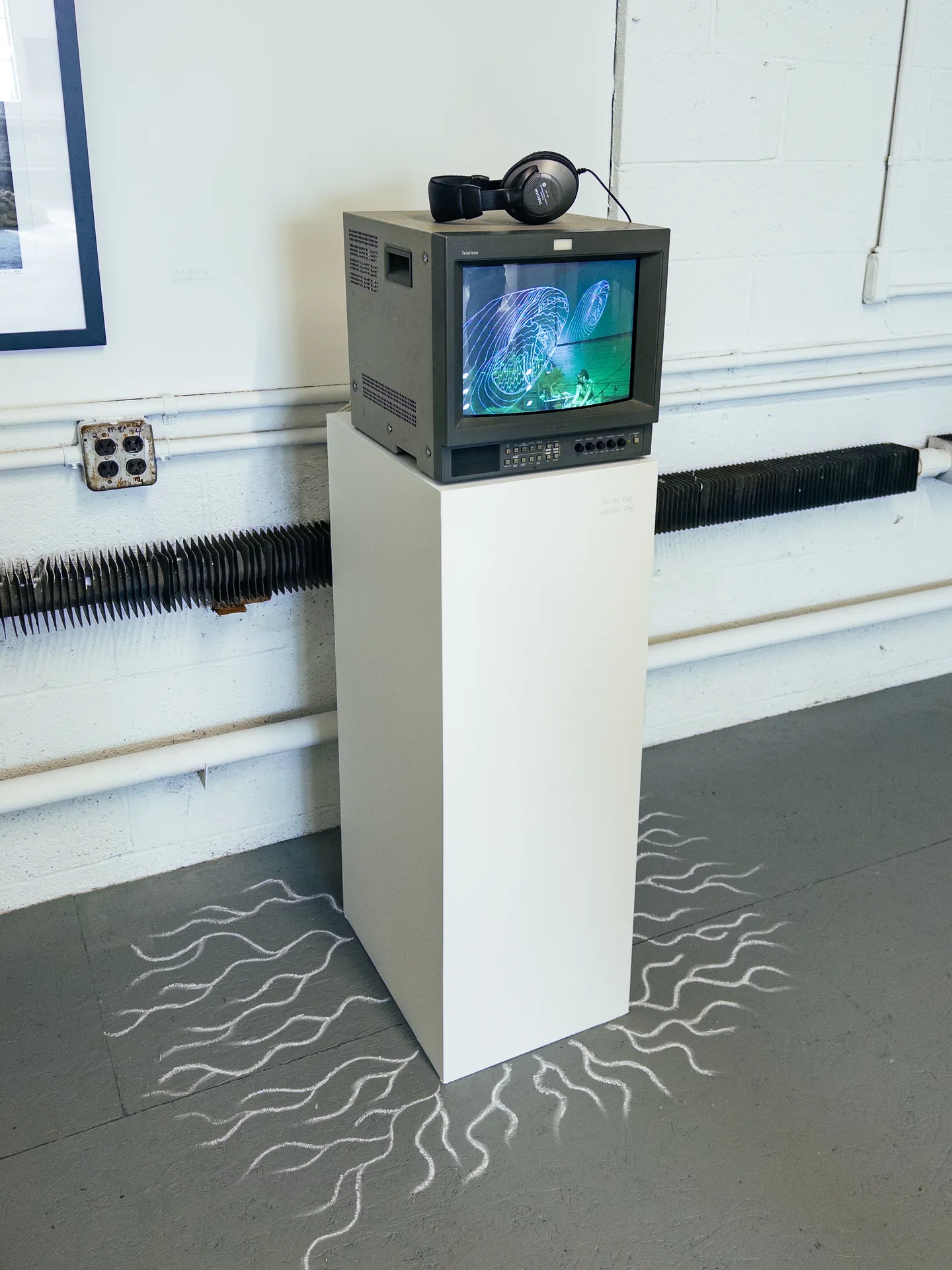 installation view of a crt playing a video with a chalk drawing like plant roots or mycelium
