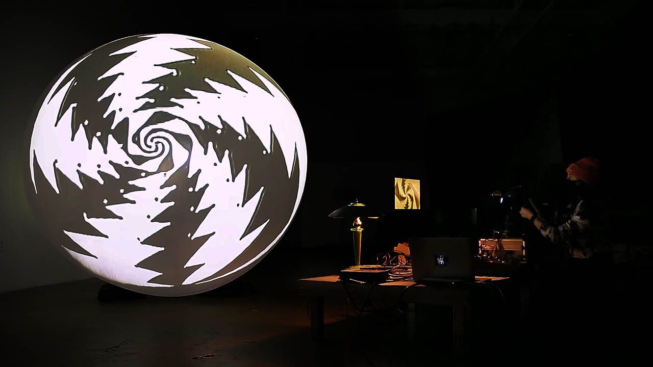 abstract video art projected on a large spherical white weather balloon