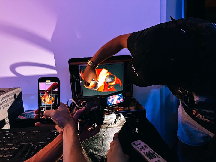 A television with video feedback, with a hand holding a glass orb in front of it