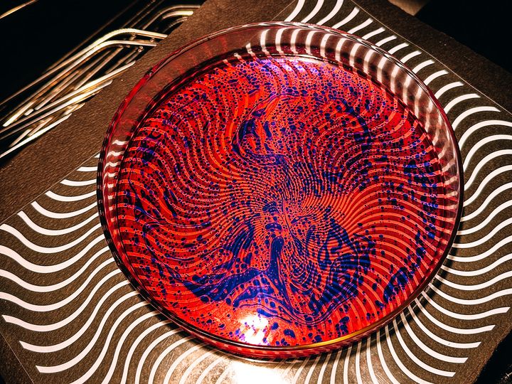 Close up photo of a liquid light show plate with an op-art style gel underneath it