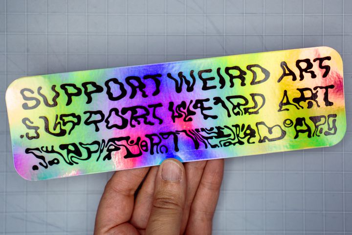 Holographic sticker with the slogan: Support Weird Art