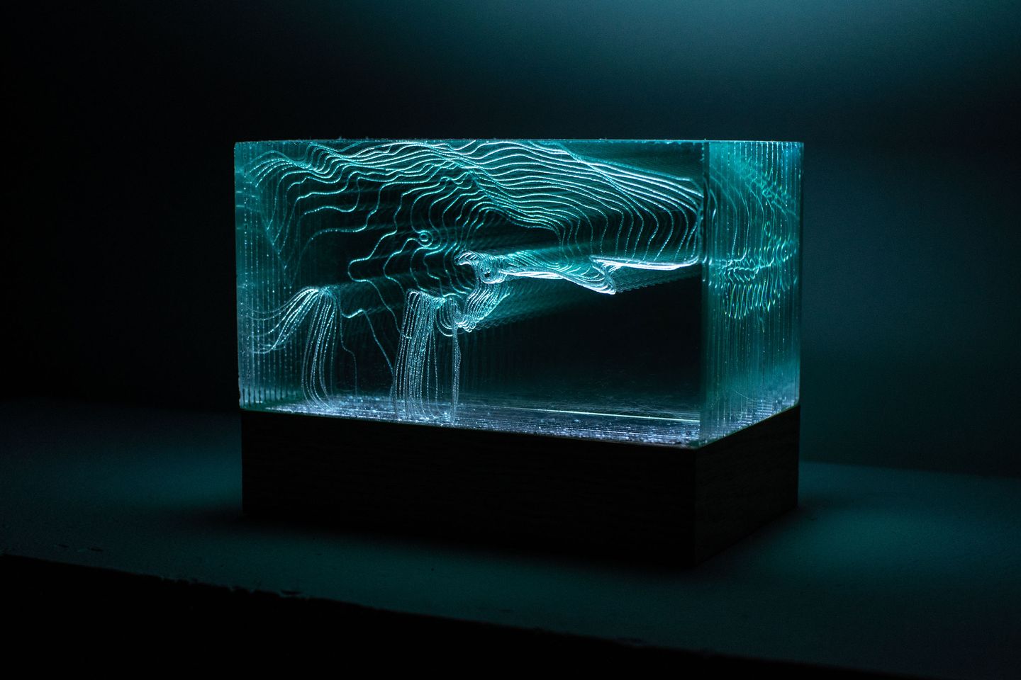 Video Topography sculpture - front view; it looks a bit like an empty glowing fish tank with floating patterns of lines inside